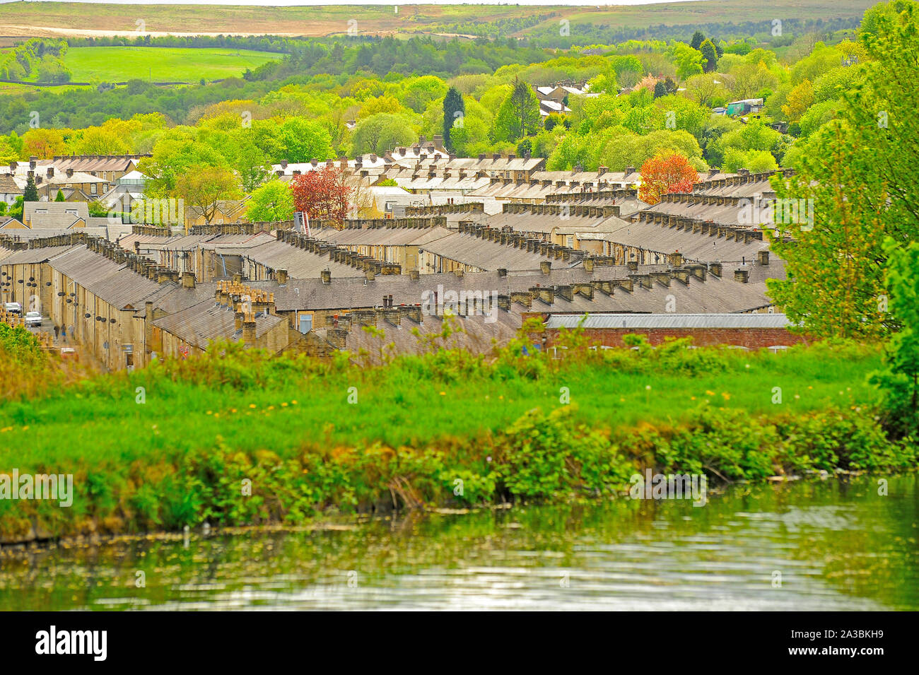 Rows of stone terrace houses below the Leeds LIverpool canal surrounded ...