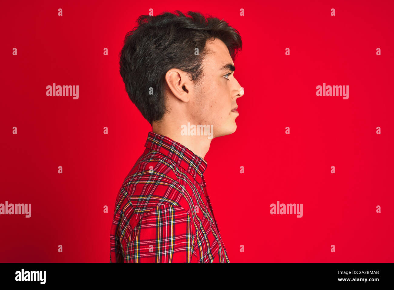 Teenager boy wearing red shirt standing over isolated background