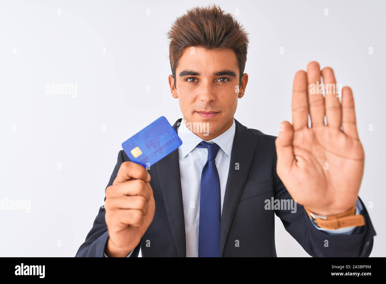 Young handsome businessman wearing suit holding credit card over ...