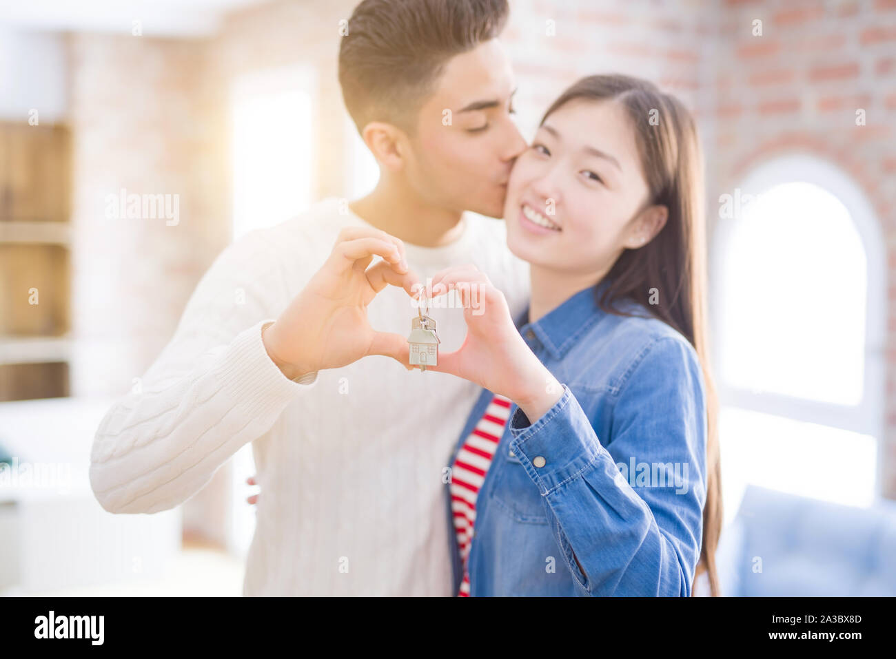 Young asian couple holding keys of new house, smiling happy and excited ...