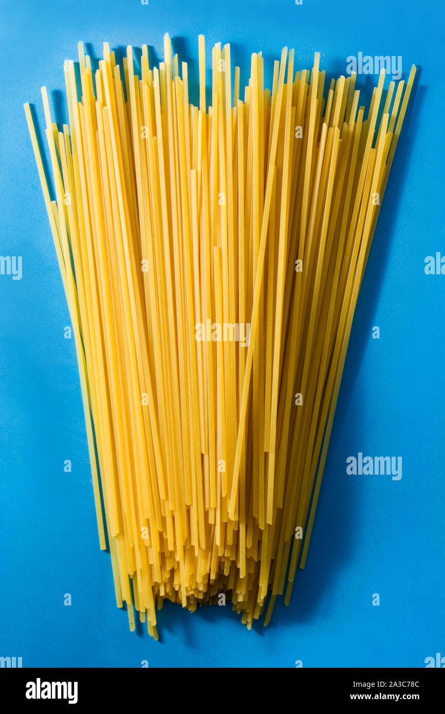 Raw Spaghetti pasta on blue background Stock Photo