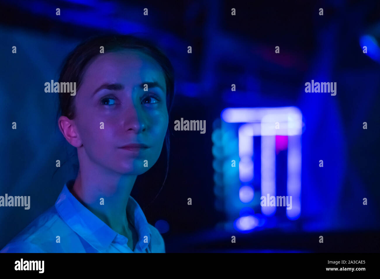 Young woman looking around at modern immersive exhibition Stock Photo ...