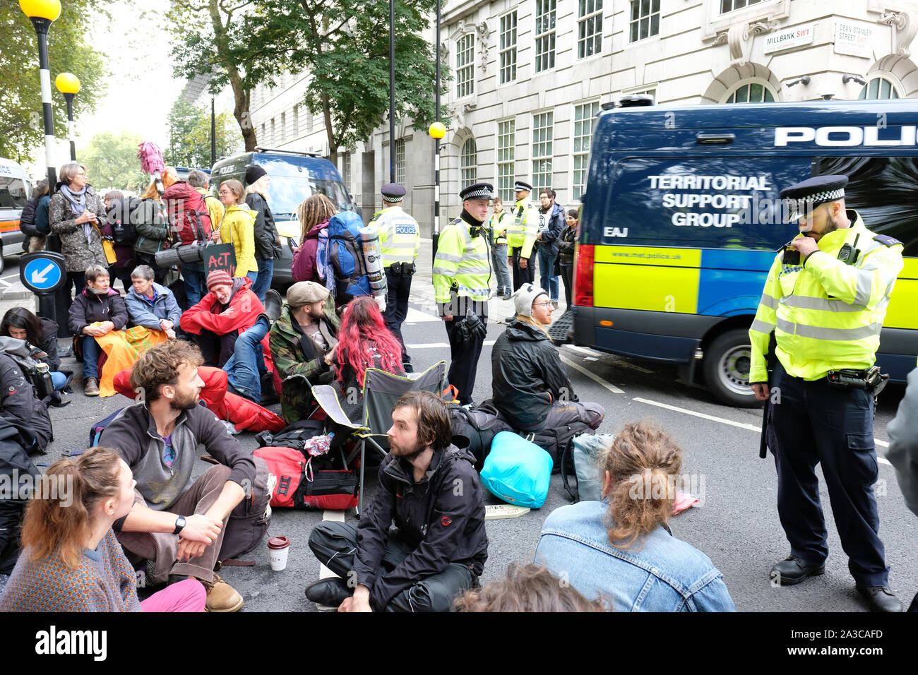 Westminster, London, UK - Monday 7th October 2019 - Extinction Rebellion XR climate protesters block roads around Westminster - Police officers watch protesters at Millbank near Parliament. Photo Steven May / Alamy Live News Stock Photo