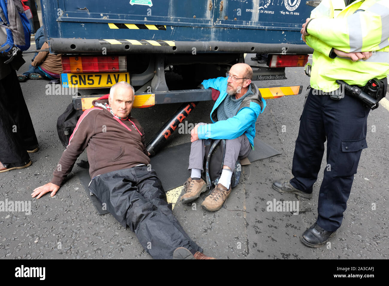 Westminster, London, UK - Monday 7th October 2019 - Extinction Rebellion XR climate protesters block Marsham Street directly outside the Home Office - the protesters parked a van across the road and several have then glued themselves to the vehicle - Police watch on. Photo Steven May / Alamy Live News Stock Photo