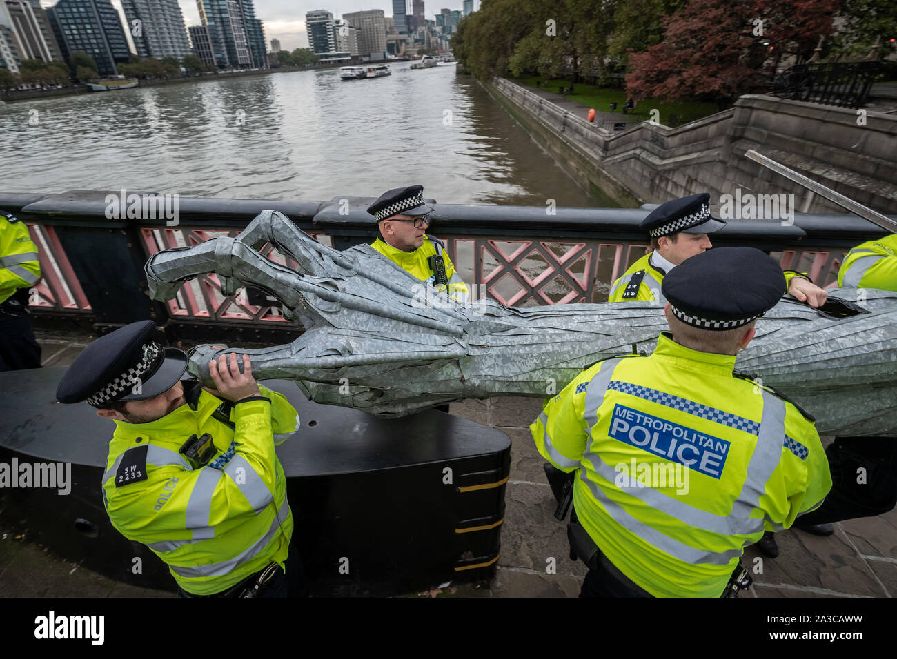 London, UK. 7th Oct, 2019. Police seize body parts of a giant metallic figure from Extinction Rebellion protesters during an occupation of Lambeth Bridge. The environmental campaigners begin a new wave of protest action this morning causing disruption in London. The Metropolitan Police confirmed 21 arrests so far this morning. Credit: Guy Corbishley/Alamy Live News Stock Photo