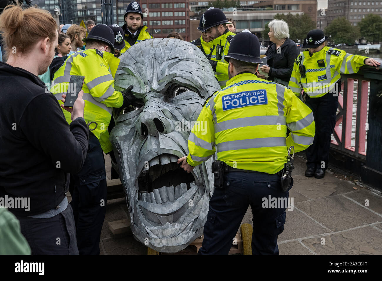 London, UK. 7th Oct, 2019. Police seize body parts of a giant metallic figure from Extinction Rebellion protesters during an occupation of Lambeth Bridge. The environmental campaigners begin a new wave of protest action this morning causing disruption in London. The Metropolitan Police confirmed 21 arrests so far this morning. Credit: Guy Corbishley/Alamy Live News Stock Photo