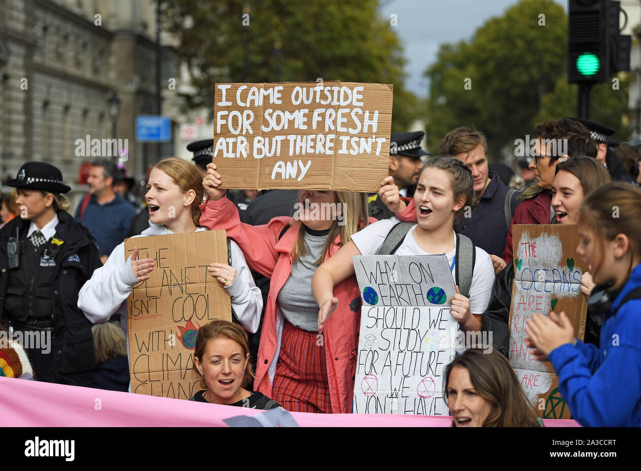 Protesters with placards on Parliament Street, during an Extinction Rebellion (XR) protest in Westminster, London. Stock Photo