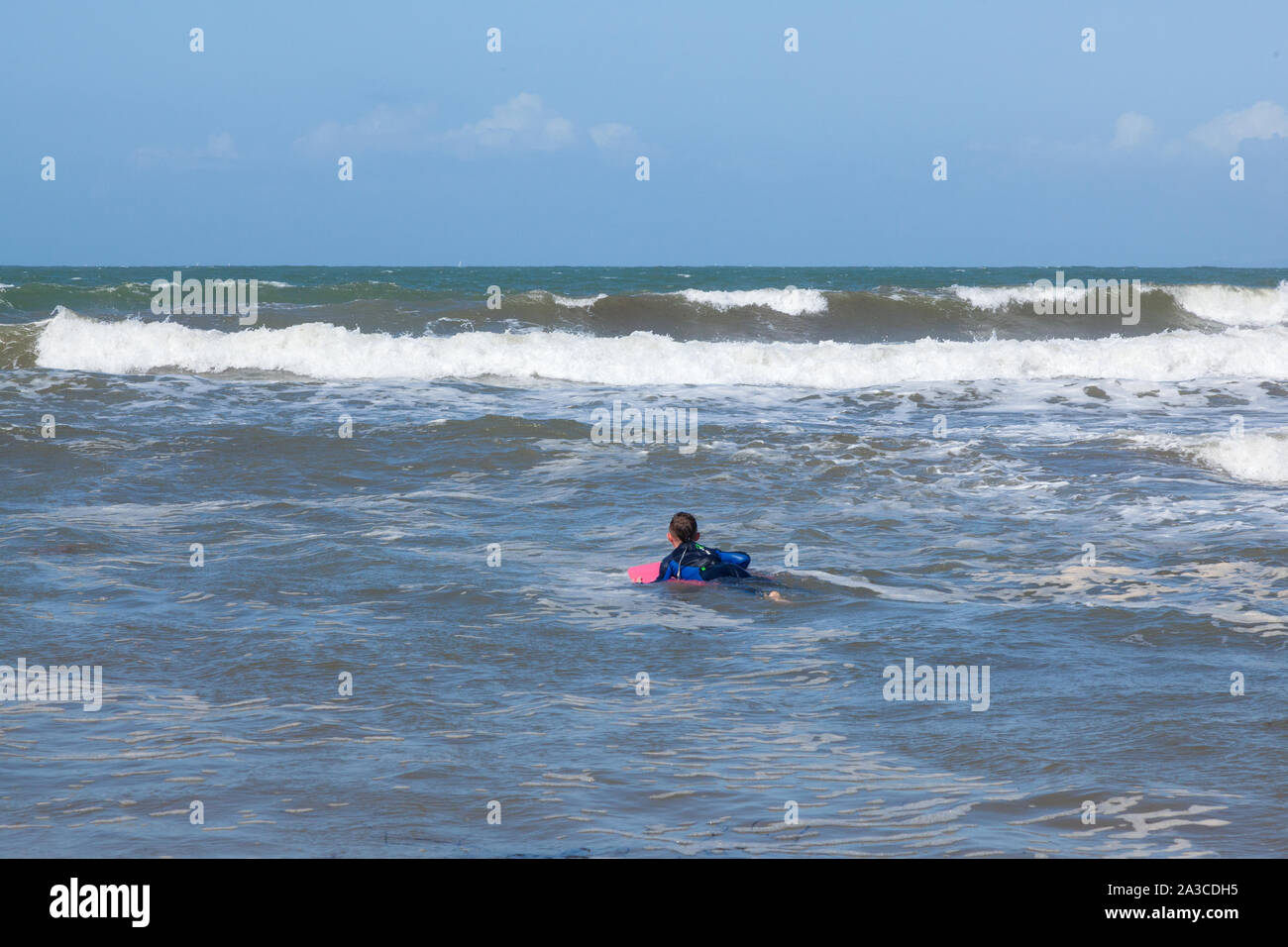 Ten year old boy surfing at Outer Hope Cove, Mouthwell sands beach, Kingsbridge, Devon, England, United Kingdom. Stock Photo