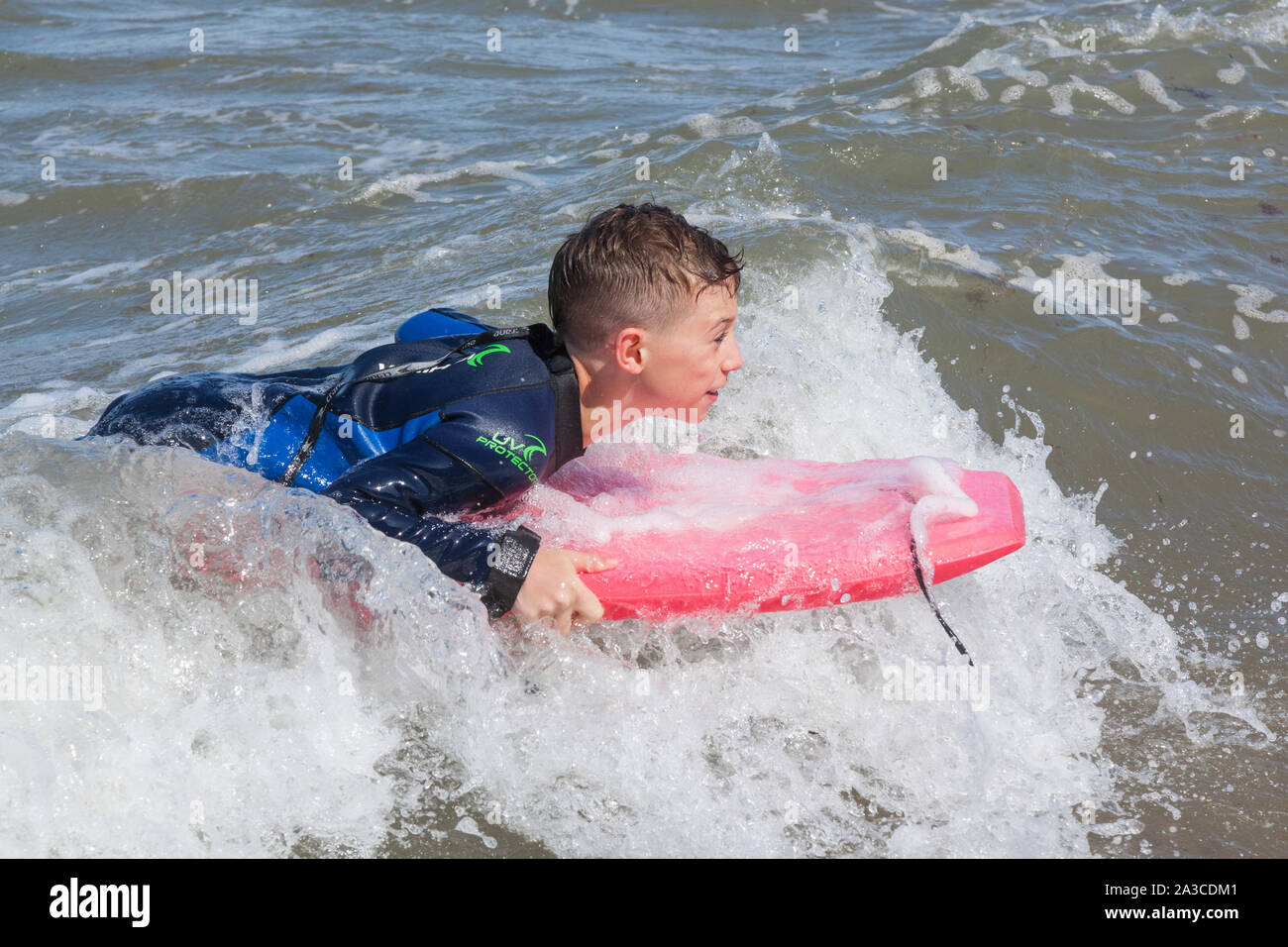 Ten year old boy surfing at Outer Hope Cove, Mouthwell sands beach