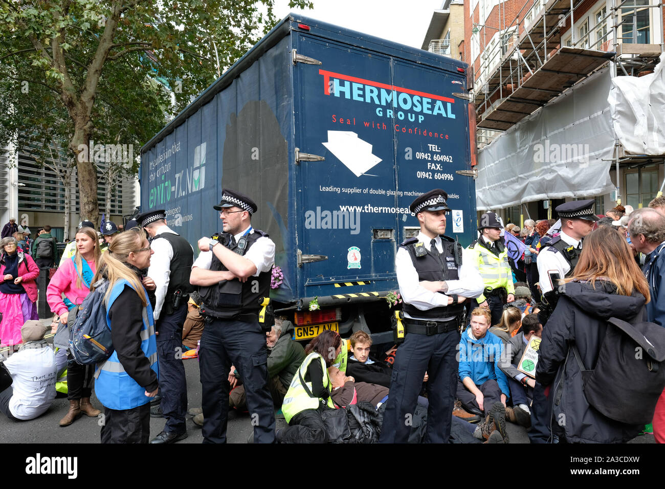 Westminster, London, UK - Monday 7th October 2019 - Extinction Rebellion XR climate protesters block Marsham Street directly outside the Home Office - the protesters parked a lorry across the road and several have then glued themselves to the vehicle - Police watch on. Photo Steven May / Alamy Live News Stock Photo