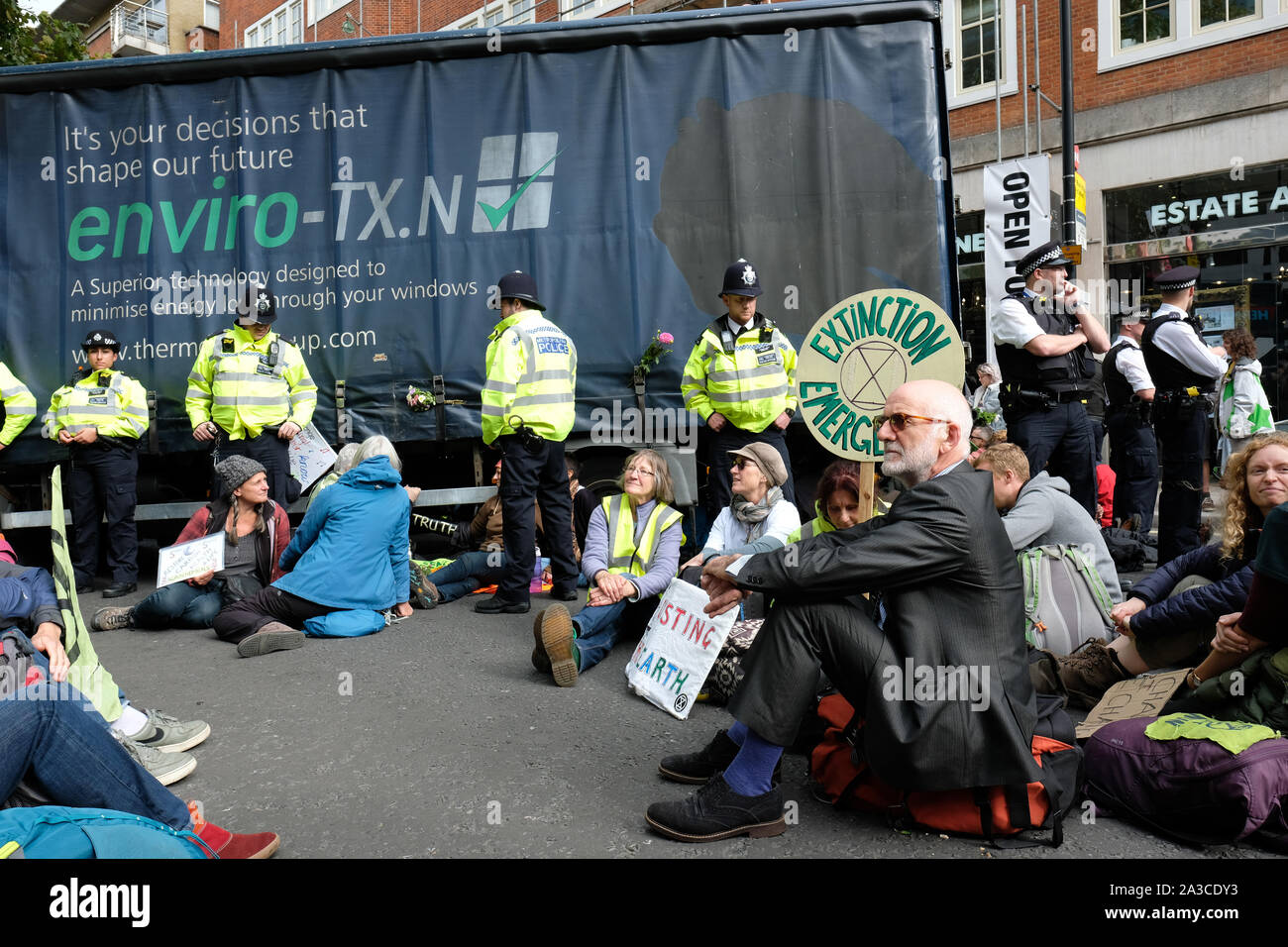 Westminster, London, UK - Monday 7th October 2019 - Extinction Rebellion XR climate protesters block Marsham Street directly outiside the Home Office - the protesters parked a lorry across the road and several have then glued themselves to the vehicle - Police watch on. Photo Steven May / Alamy Live News Stock Photo