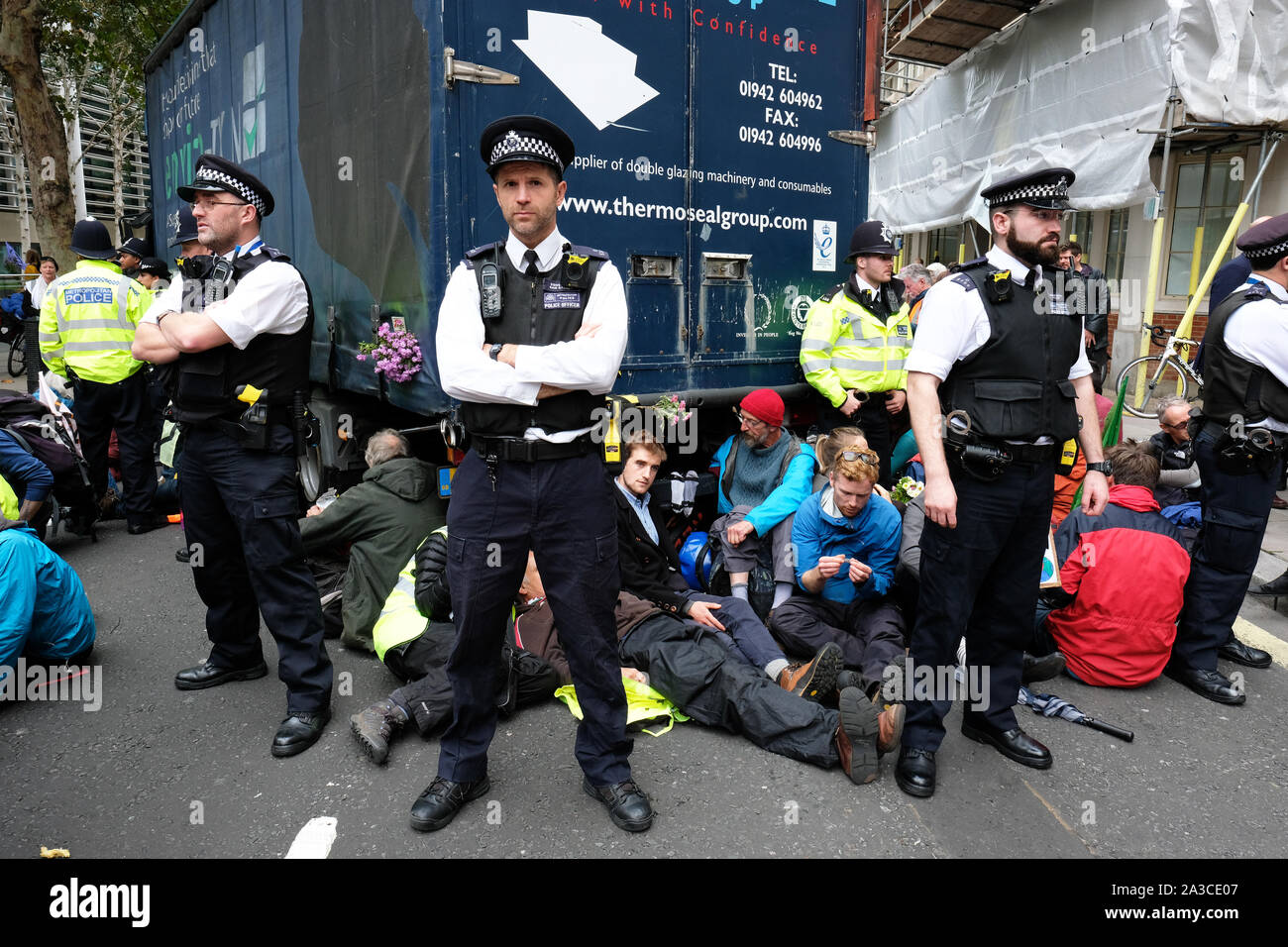Westminster, London, UK - Monday 7th October 2019 - Extinction Rebellion XR climate protesters block Marsham Street directly outside the Home Office - the protesters parked a lorry across the road and several have then glued themselves to the vehicle - Police watch on. Photo Steven May / Alamy Live News Stock Photo