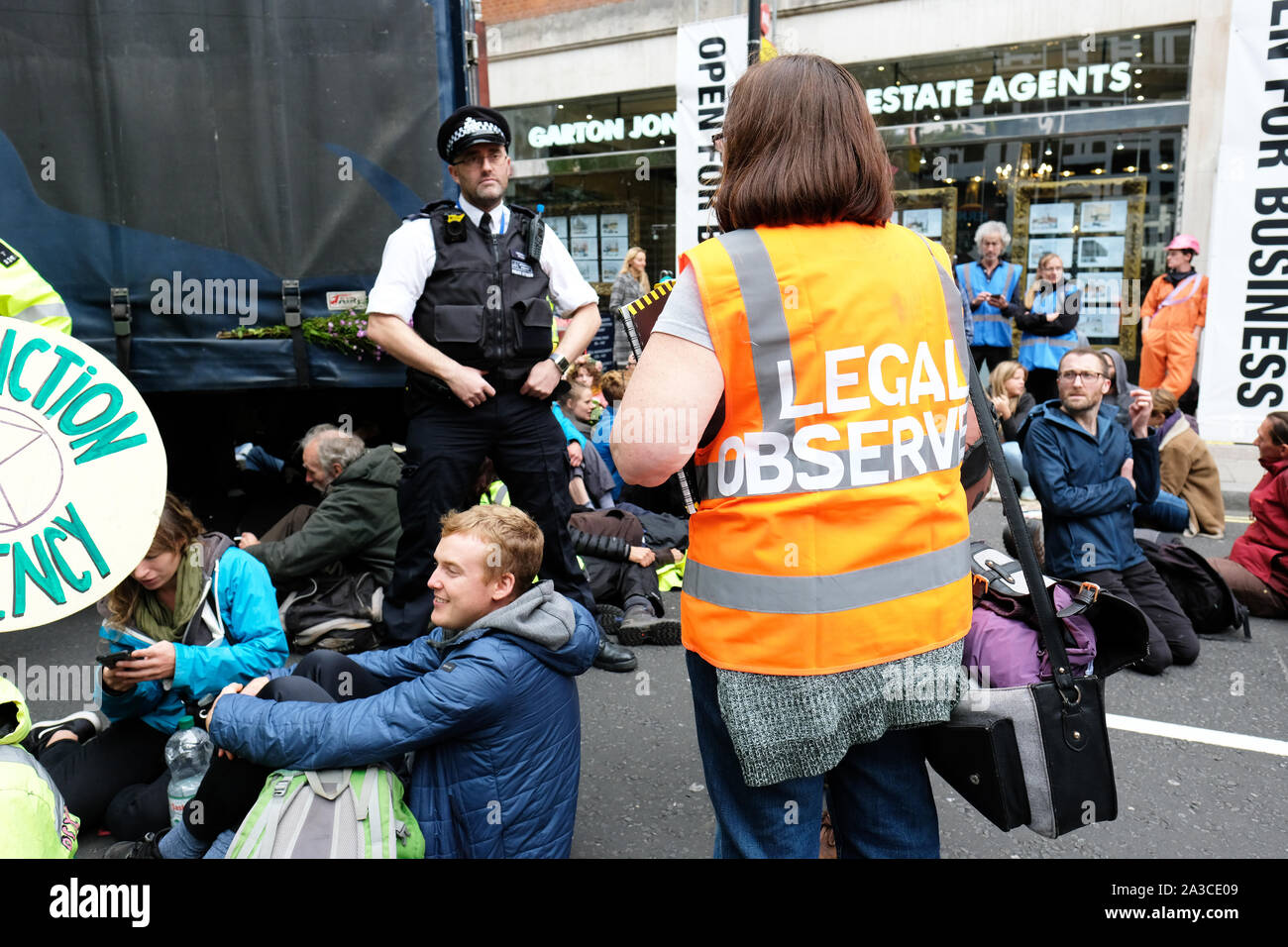 Westminster, London, UK - Monday 7th October 2019 - Extinction Rebellion XR climate protesters block Marsham Street directly outside the Home Office - the protesters parked a lorry across the road and several have then glued themselves to the vehicle - Police and a Legal Observer watch on. Photo Steven May / Alamy Live News Stock Photo