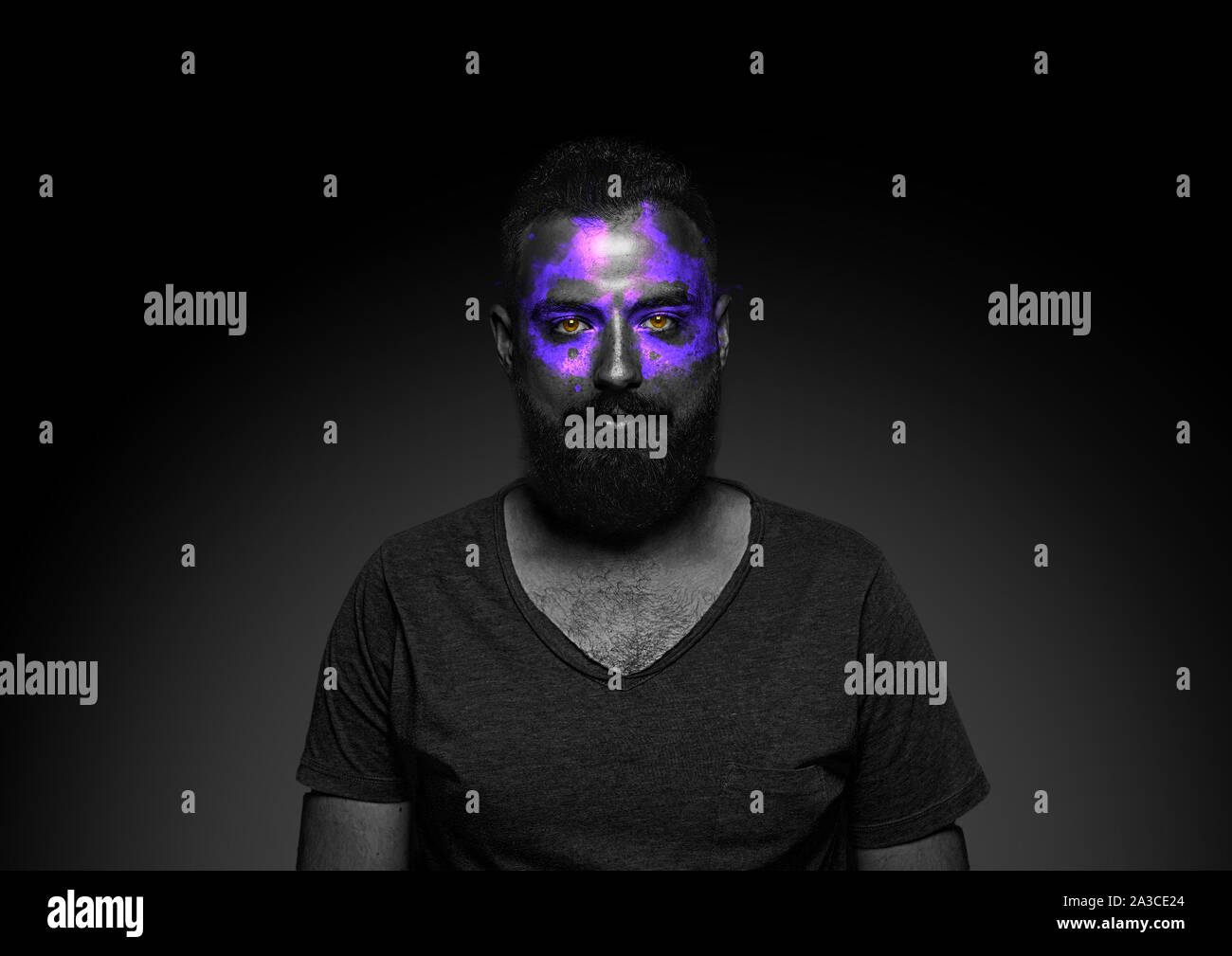 Discover what's inside you. Close up portrait of young man isolated on black studio background. Bright neon light on the face. Halloween, scary look theme, october holidays, horror concept. Stock Photo