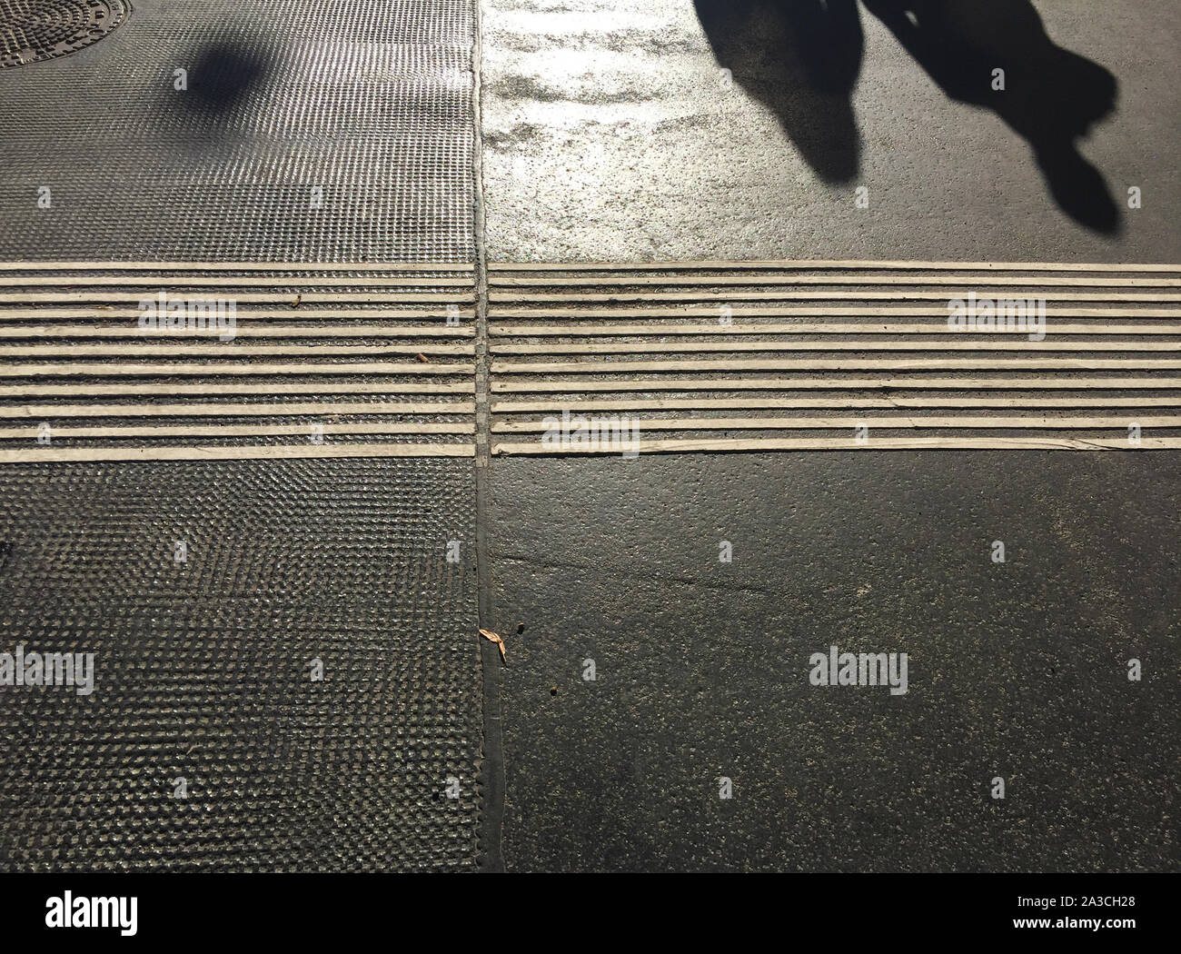 Legs and shadows of people on pavement Stock Photo