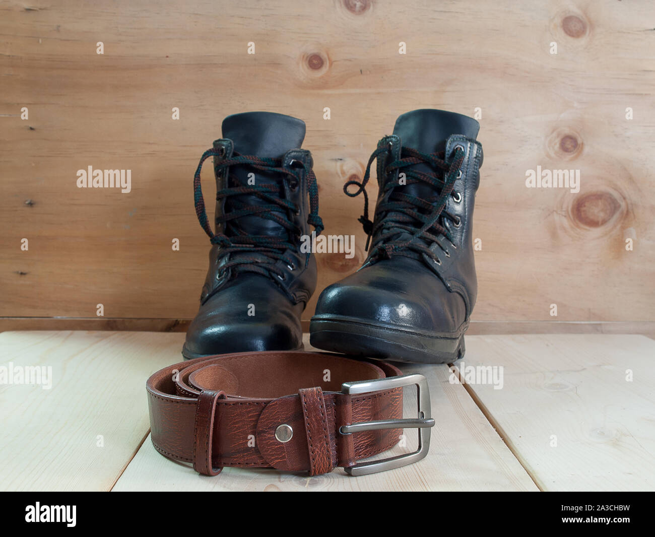 classic black shoes and belt on wooden table. Stock Photo