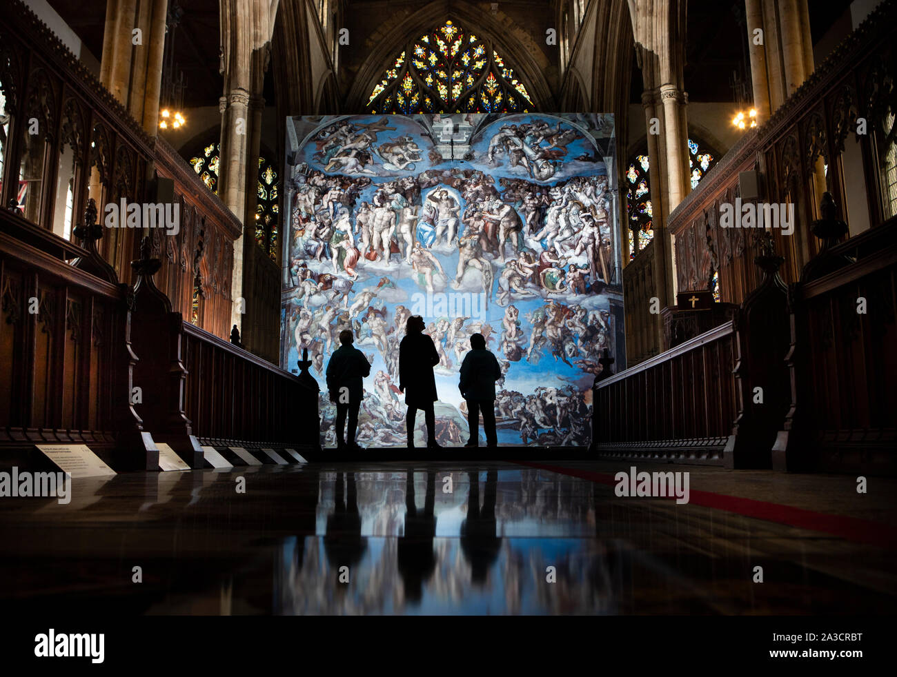 People are reflected as they view a reproduction of Michelangelo's The Last Judgement, ahead of the opening of for the Michelangelo: A Different View exhibition at Hull Minister. Stock Photo