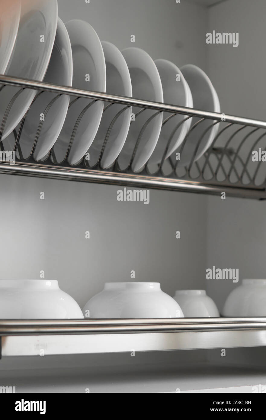 Dish drying metal rack with big nice white clean plates. Traditional