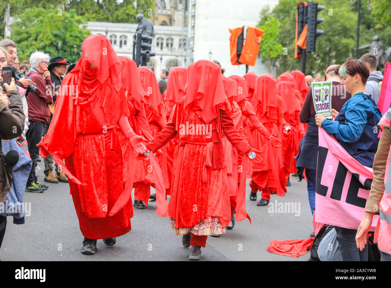 London, UK. 07th Oct, 2019. The Red Brigade in their blood red outfits once again make an appearance. Climate activists from Extinction Rebellion have staged a number of protests at various sites in Westminster, including Bridges and several government ministries, to raise awareness on global climate emergency issues. Credit: Imageplotter/Alamy Live News Stock Photo