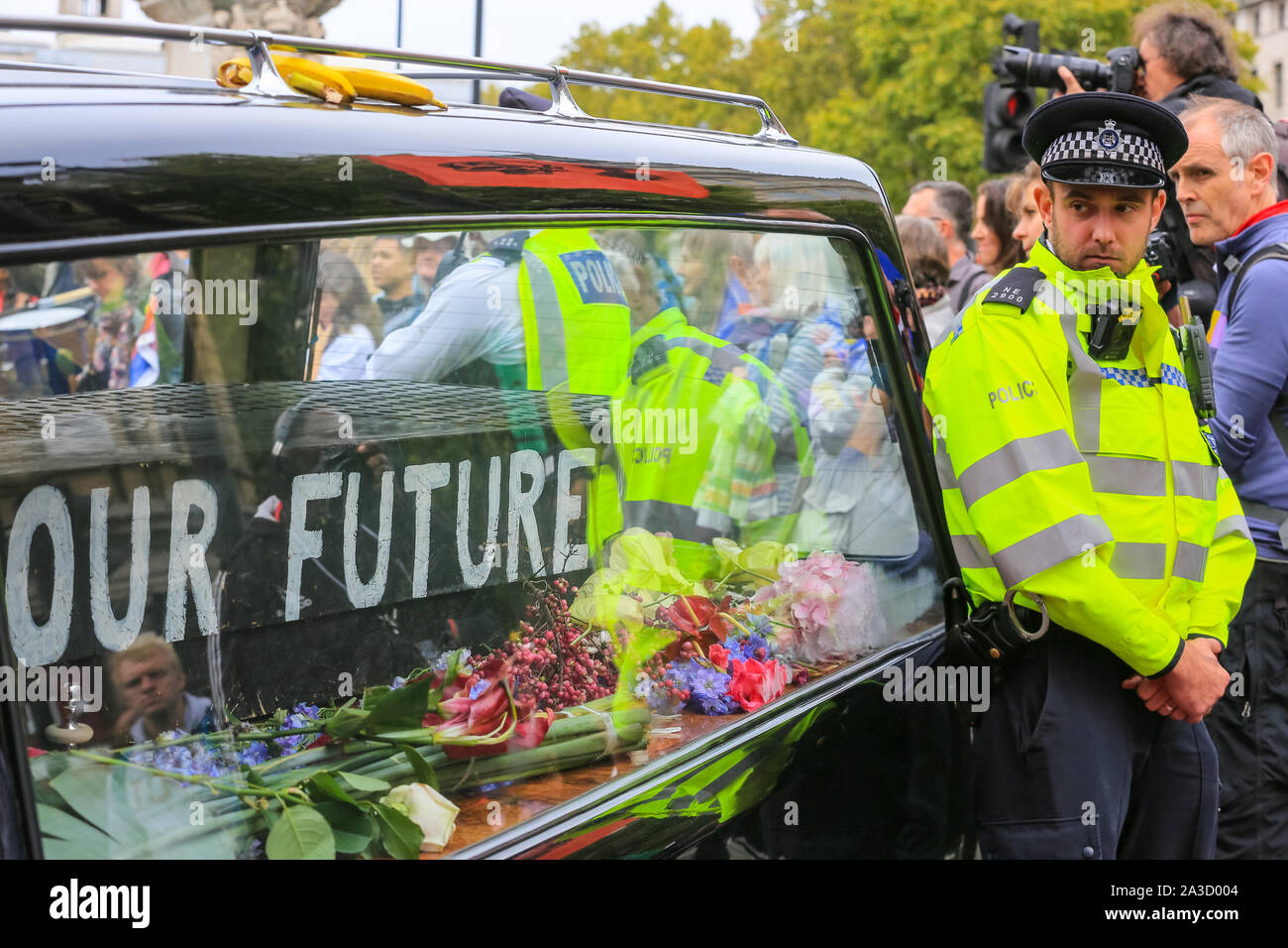 London, UK. 07th Oct, 2019. Two protesters have chained themselves into a funeral hearse complete with coffin, incscribed 'Our Future'. Climate activists from Extinction Rebellion have staged a number of protests at various sites in Westminster, including Bridges and several government ministries, to raise awareness on global climate emergency issues. Credit: Imageplotter/Alamy Live News Stock Photo