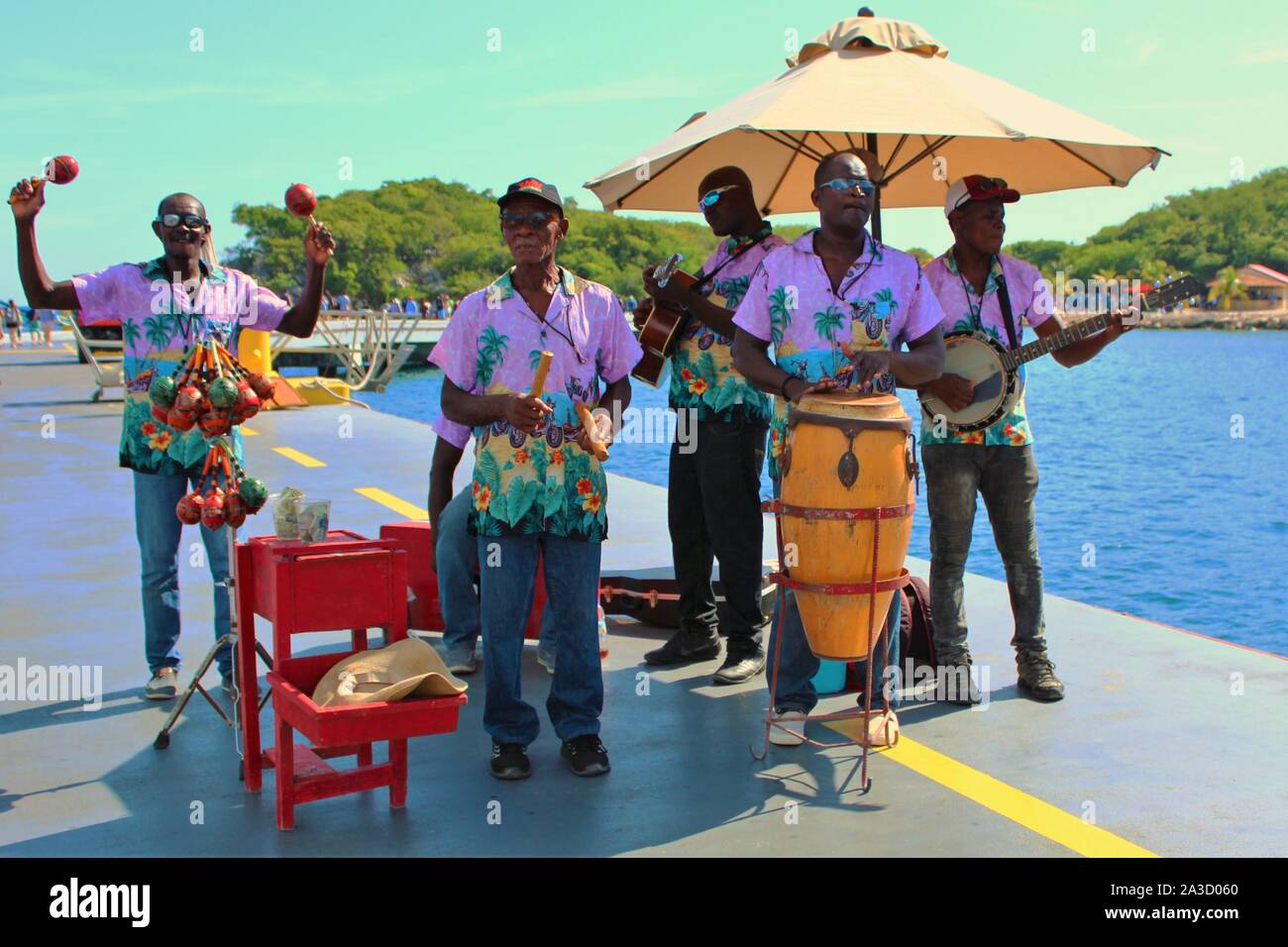 Local musicians play traditional music to greet the passengers arriving off of a Royal Caribbean cruise ship to it's privately owned resort of Labadee Stock Photo