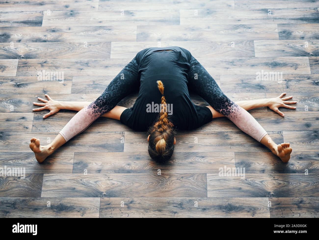 Top view of young woman practicing yoga doing the turtle pose