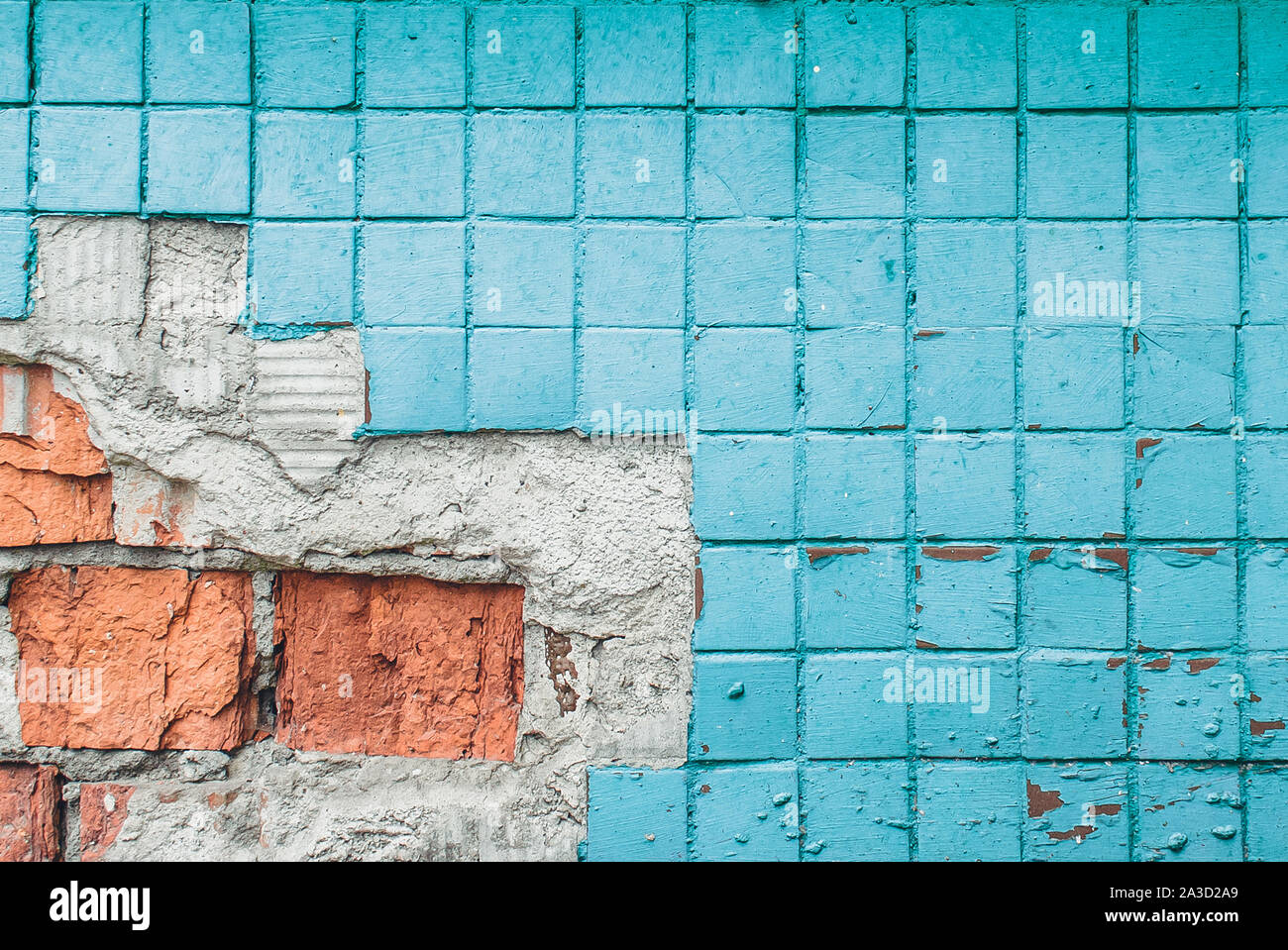 Texture of old blue tile wall. Background of Wall fragment with broken tile and bricks Stock Photo