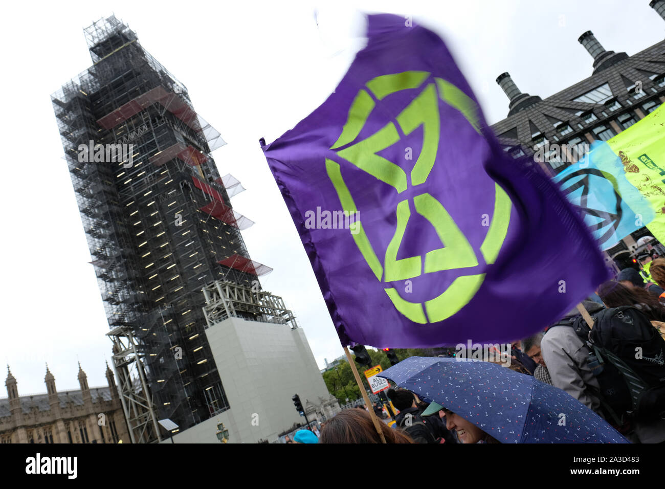 Westminster, London, UK - Monday 7th October 2019 - An Extinction Rebellion XR flag flutters in the rain on Westminster Bridge beside Big Ben.  Photo Steven May / Alamy Live News Stock Photo