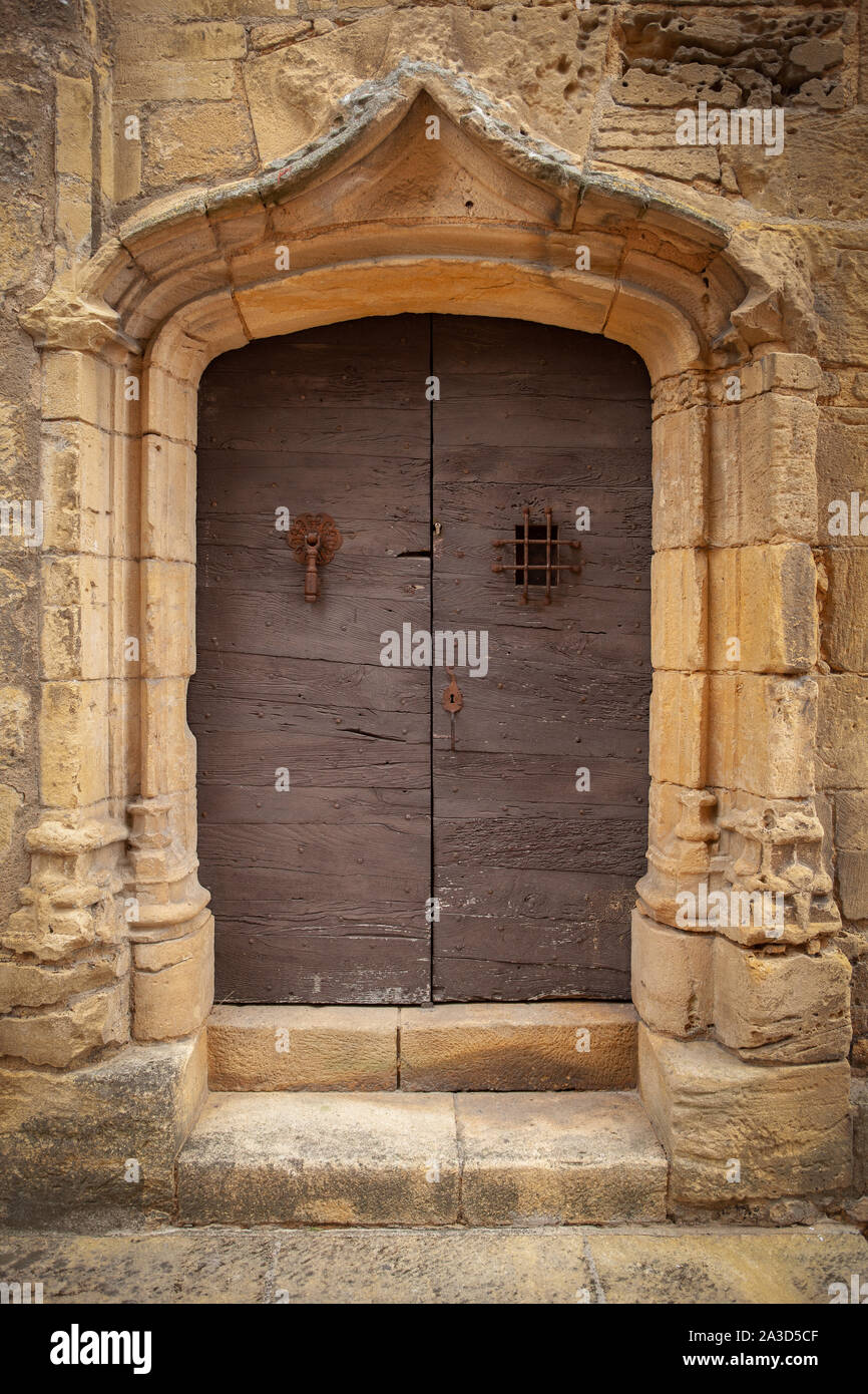 Old wooden door with ornate medieval stone doorway Stock Photo