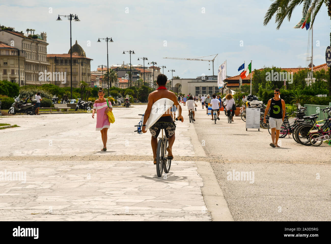 View of the seafront of Viareggio, popular tourist destination on the Versilia coast, with tourists walking and cycling in summer, Tuscany, Italy Stock Photo
