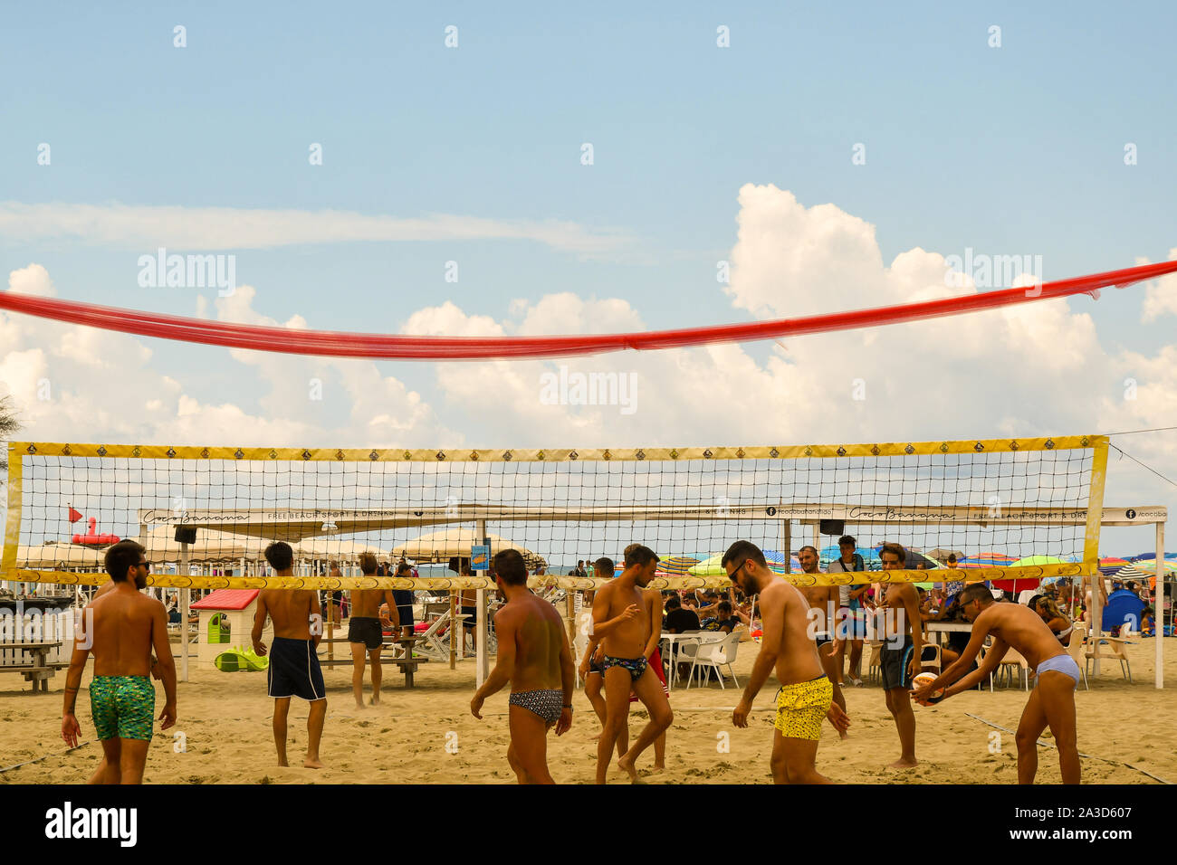 Young men playing beach volleyball on the seashore of Lido di Camaiore in a sunny mid-August day, Versilia, Tuscany, Italy Stock Photo