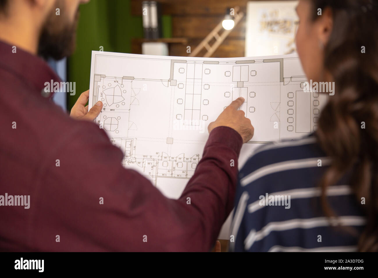 Two colleagues discussing the avant-garde project with a blue print. Close up and two person Stock Photo