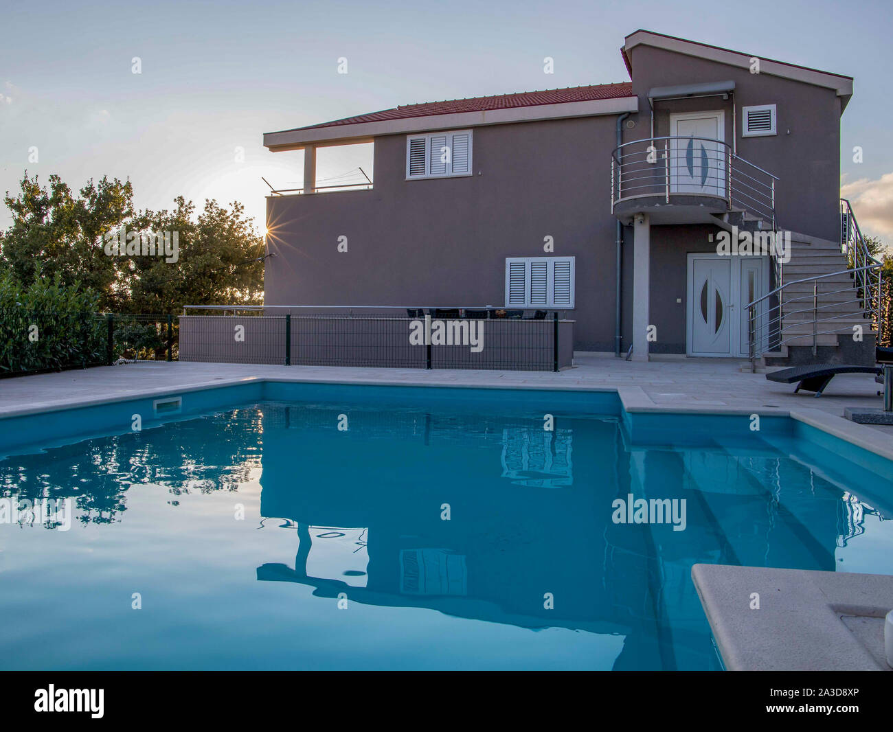 modernes luxuriöses Haus mit privatem Pool während des Sonnenuntergangs Luxushaus Stock Photo