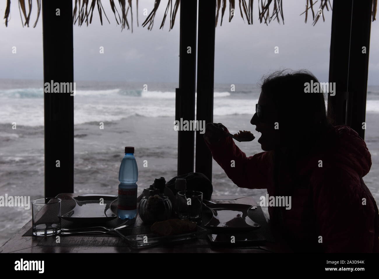 Hanga Roa, Chile. 23rd Sep, 2019. A woman is seen eating in a restaurant near fishing port.Hanga Roa is the capital of Easter Island, a Chilean island in the southeastern Pacific Ocean. The village has around 5,000 inhabitants, which comprises between 87 and 90 percent of the total population of the island. Excluding a small percentage still engaged in traditional fishing and small-scale farming, the majority of the population is engaged in tourism which is the main source of income. Credit: John Milner/SOPA Images/ZUMA Wire/Alamy Live News Stock Photo