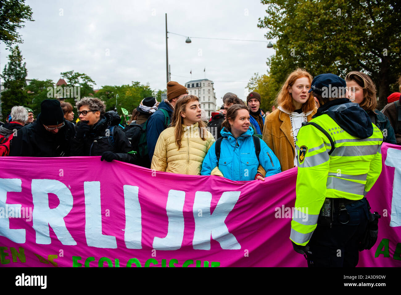 A dutch police officer speaks with some of the activists during the protest.For 2 weeks, Extinction Rebellion and allied movements will gather in major cities across the globe and continue to rebel against the world’s governments for their criminal inaction on the Climate and Ecological Crisis. XR climate activists in Amsterdam are going to organize a large-scale blockade lasting several days on the Museumbrug, in front of the Rijksmuseum. From early in the morning, hundreds of XR activists showed up on the bridge, where there was a visible police presence. The Environmental group extinction R Stock Photo