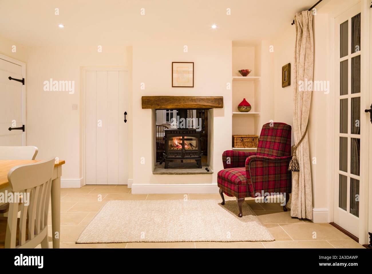 Country home interior, open plan room with wood burning stove in winter Stock Photo