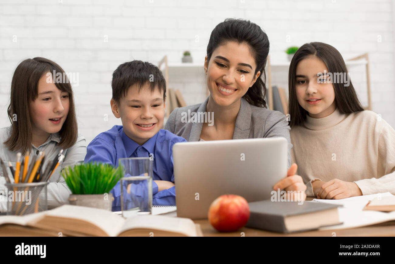 Young teacher showing children tutorials online on tablet Stock Photo