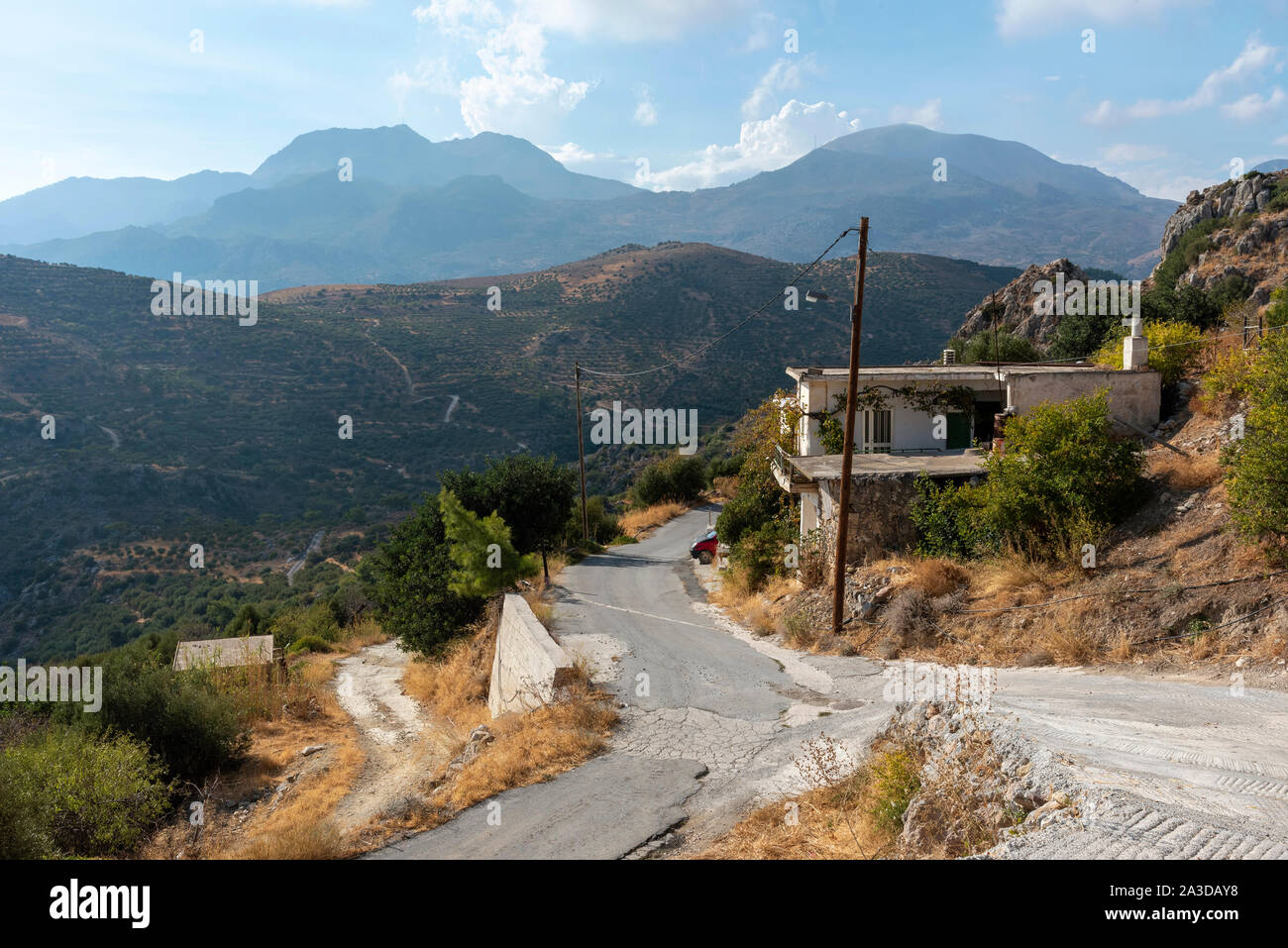 Agios Stefanos, Crete, Greece. September 2019.  Rural scenic road passing a Cretan home on the roadside in this mountainside ancient village of Agios Stock Photo