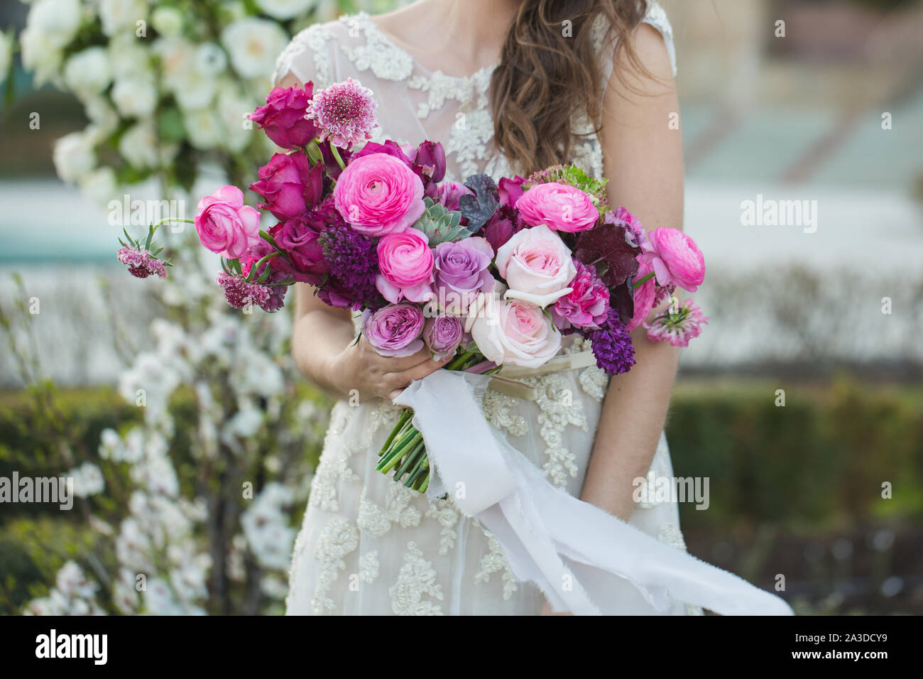 Bride with beautiful wedding bouquet. Pink rose and other flowers. Stock Photo