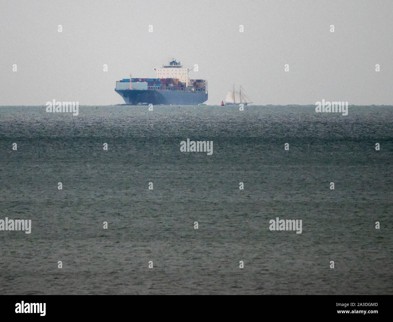 Sheerness, Kent, UK. 7th October, 2019. Historic sailing ship De Gallant seen sailing  passing Sheerness, Kent just before nightfall this evening in foul weather before anchoring overnight. De Gallant is transporting a special cargo of wine, coffee, spices and more to London. It’s thought to be the first major cargo arriving by sail since the 1960s. Picture: seen crossing the path of modern containership SM Charleston. Credit: James Bell/Alamy Live News Stock Photo