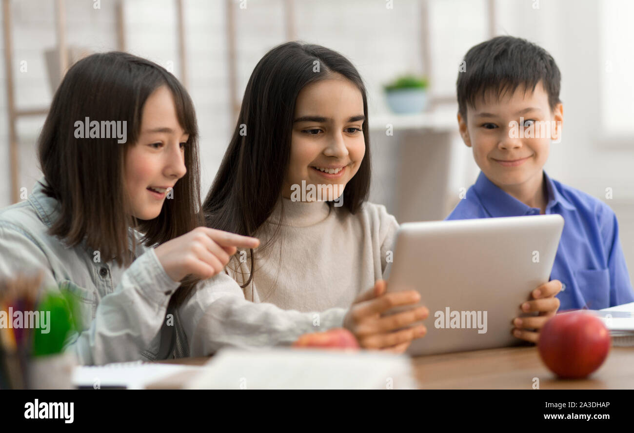 Children watching videos on digital tablet in class Stock Photo