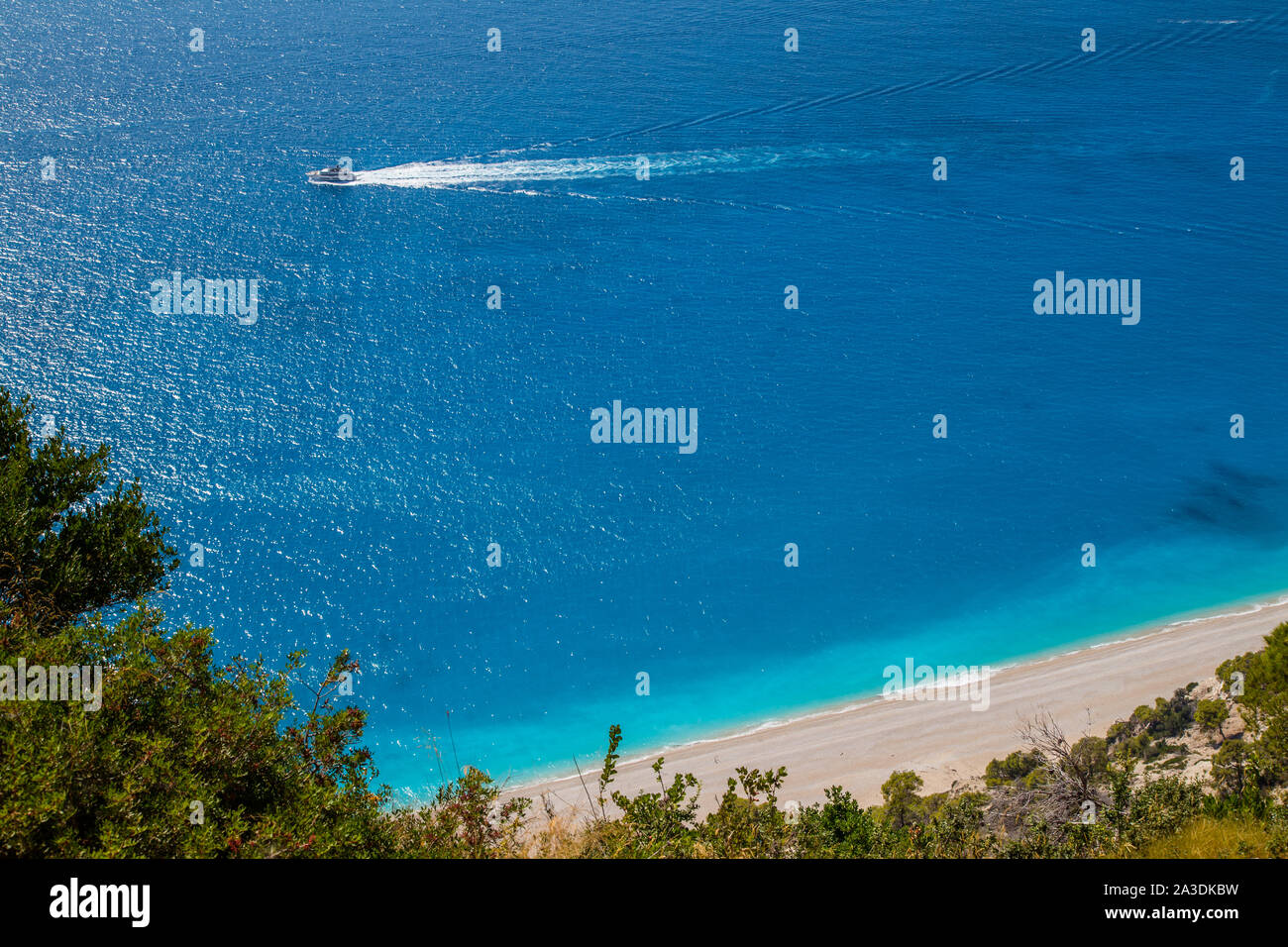 Motor yacht passing Egremni beach on the west coast of Lefkada / Lefkas Island, Greece Stock Photo