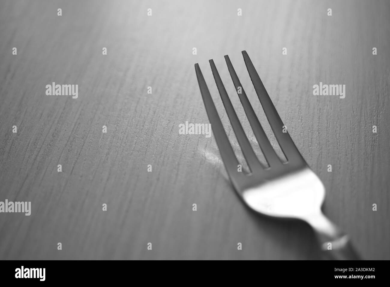 fork on the wooden table, black and white photo. Stock Photo