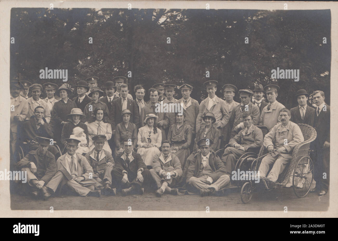Vintage Early 20th Century Photographic Postcard Showing a Group of Injured and Sick WW1 British Army Soldiers. One of Soldiers is in a Wheelchair. Stock Photo
