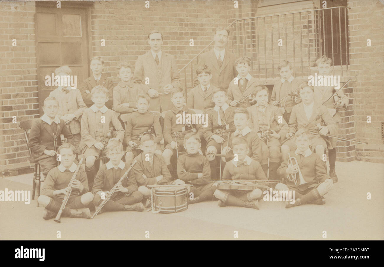 Vintage Early 20th Century Photographic Postcard Showing a Boys School Band / Orchestra. Stock Photo