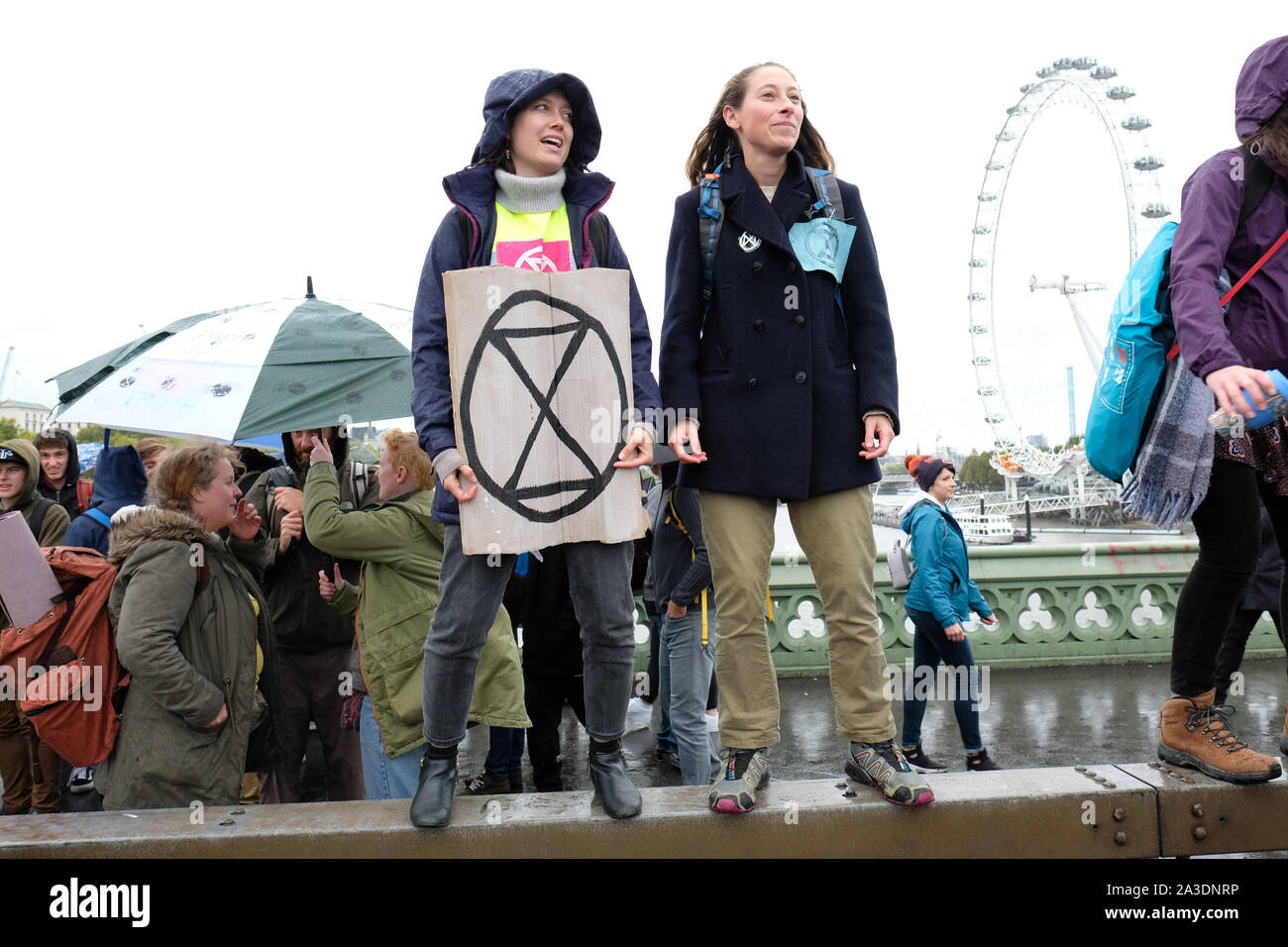 Westminster, London, UK - Monday 7th October 2019 - Two young female Extinction Rebellion XR climate protesters enjoy the wind and rain in the middle of Westminster Bridge on Day 1 of the XR protest. Photo Steven May / Alamy Live News Stock Photo