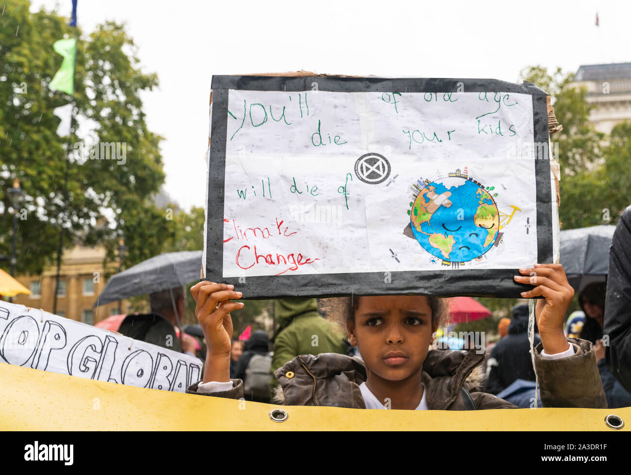 7th Oct 2019 - London, UK. A young climate change activist holds the banner at Extinction Rebellion protest in London. Stock Photo