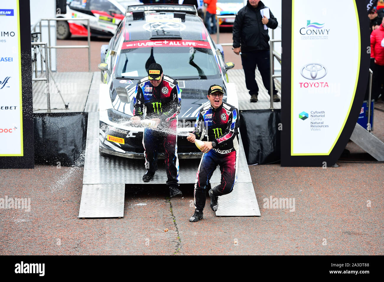 6th October 2019, Wales ; Wales Rally GB 2019 Podium: Petter SOLBERG & Co Driver Phil MILLS competing in the Volkswagen Polo R5 celebrate by spraying Champagne on friends and family Credit: Gareth Dalley/News Images Stock Photo