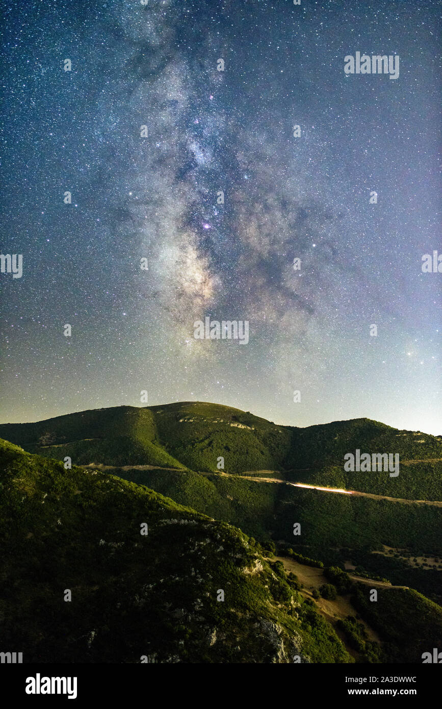 astrophotography, night photography, milky way with mountains and a road Stock Photo
