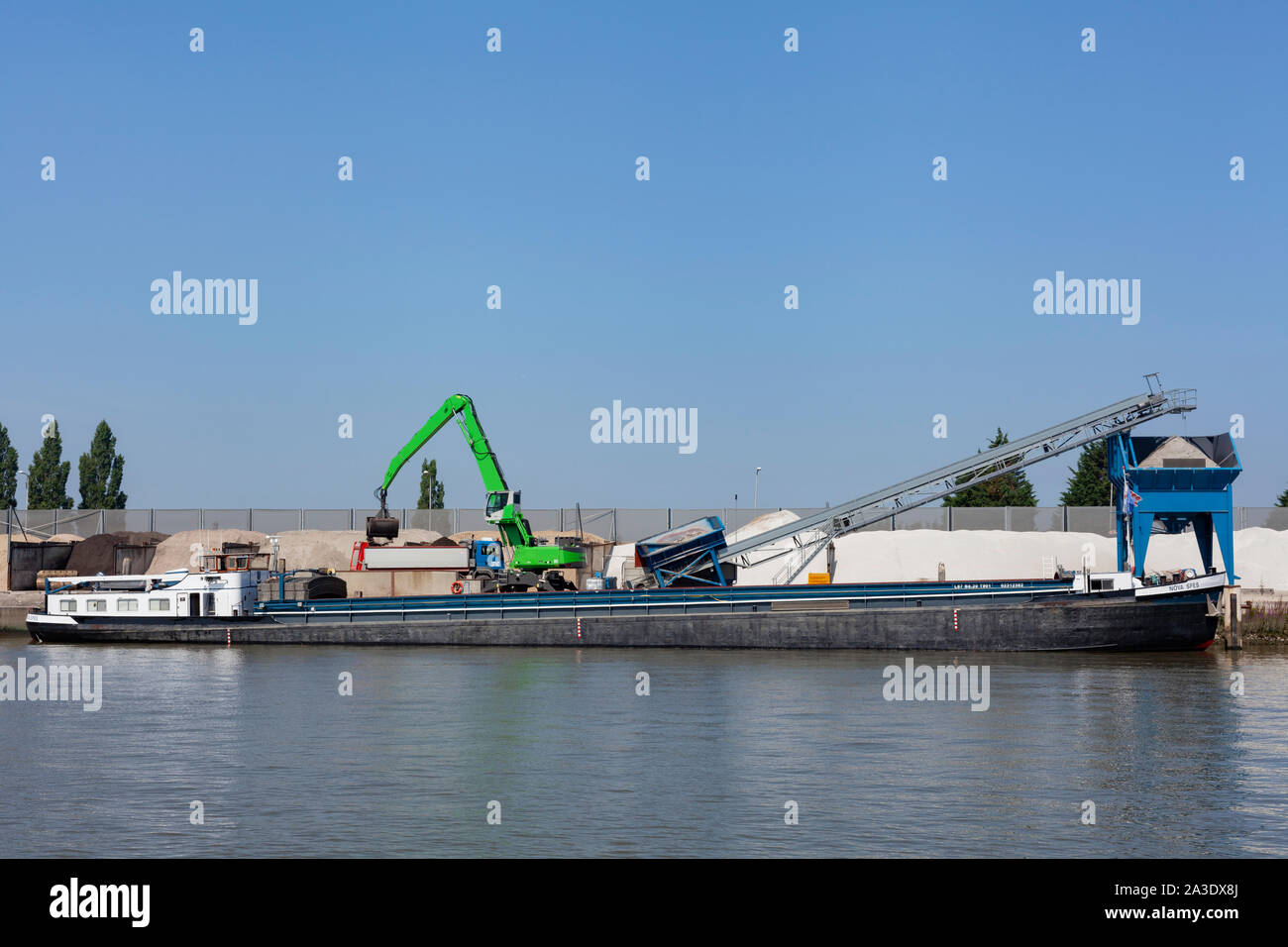 Loading barge with sand and rubble on a small berth. Freight transport